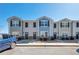 Street view of townhomes featuring varied colors, well-kept landscaping, and a blue BMW parked out front at 402 Whippet St, Union City, GA 30291