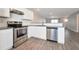 Modern kitchen with stainless appliances, granite counters, white subway tile backsplash, and gray flooring at 402 Whippet St, Union City, GA 30291