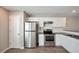 Well-lit kitchen offers stainless steel appliances, white cabinetry, and sleek, gray countertops at 402 Whippet St, Union City, GA 30291