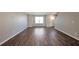 Living room features hardwood floors, neutral paint, large window, and staircase at 402 Whippet St, Union City, GA 30291
