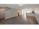 Open living room showcasing hardwood floors, neutral paint, stairs to the second floor, and access to a bathroom at 402 Whippet St, Union City, GA 30291