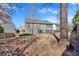 View of the gray siding of home's back exterior, a large tree, and the grassy backyard at 510 Pinchot Way, Woodstock, GA 30188