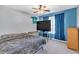 Bedroom with blue accent wall, ceiling fan, a tv and a window with dark blue curtains at 510 Pinchot Way, Woodstock, GA 30188