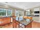 Bright, open kitchen with a granite island, wooden cabinets, and view of an adjacent living space at 510 Pinchot Way, Woodstock, GA 30188