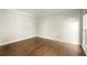 Empty bedroom with hardwood floors, white walls and trim, and a window at 6268 Braidwood Nw Run, Acworth, GA 30101