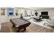 Living room featuring a pool table, large sectional couch, and plenty of natural light at 6268 Braidwood Nw Run, Acworth, GA 30101