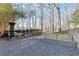 A tiered backyard features a deck, gravel area, retaining walls, and mature trees at 650 Vinings Estates Se Dr, Mableton, GA 30126