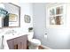 Powder room featuring a modern vanity with a sleek sink and a decorative mirror above the toilet at 650 Vinings Estates Se Dr, Mableton, GA 30126