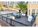 An expansive deck features a modern outdoor dining set and black metal railings overlooking the lush landscape at 650 Vinings Estates Se Dr, Mableton, GA 30126