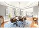 Bright dining room features a modern light fixture and a long table with wooden chairs on wheels at 650 Vinings Estates Se Dr, Mableton, GA 30126