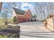 Brick home featuring a three-car garage and a driveway leading to a back deck at 650 Vinings Estates Se Dr, Mableton, GA 30126