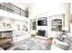 Bright living room with fireplace, built-in bookshelves, hardwood floors, and second-floor balcony at 650 Vinings Estates Se Dr, Mableton, GA 30126