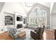 Bright living room featuring high ceilings, built-in shelving, a fireplace, and large arched windows at 650 Vinings Estates Se Dr, Mableton, GA 30126