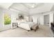 Bright primary bedroom features a king bed, neutral color palette, and natural light from surrounding windows at 650 Vinings Estates Se Dr, Mableton, GA 30126