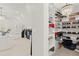 Spacious walk-in closet featuring custom shelving, ample storage, and a chandelier at 650 Vinings Estates Se Dr, Mableton, GA 30126