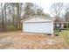 A detached two car garage with a white door and an extended driveway at 8951 Brewer Rd, Douglasville, GA 30134