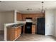 Functional kitchen with wood cabinets, black appliances, and a neutral color scheme at 312 Lauren Dr, Fairburn, GA 30213