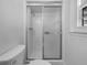 Bathroom with a sliding glass door, shower head, and toilet, offers practical design at 6691 Birch Dr, Winston, GA 30187