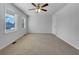 A large empty room features two windows that provide natural light, neutral carpet, and a ceiling fan at 6691 Birch Dr, Winston, GA 30187