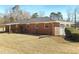 An exterior view of a single-story brick house featuring tidy landscaping and a view of the backyard at 6691 Birch Dr, Winston, GA 30187