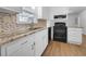This kitchen features white cabinets, modern appliances, and stylish countertops for a clean aesthetic at 6691 Birch Dr, Winston, GA 30187