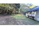 View of backyard and long gravel driveway with a detached building and a wooded area beyond at 8083 Highway 166, Douglasville, GA 30135