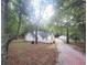 Exterior view of home and a gravel driveway in a wooded area at 8083 Highway 166, Douglasville, GA 30135