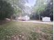Charming home featuring a wooden deck and complemented by a storage shed, all surrounded by lush greenery at 8083 Highway 166, Douglasville, GA 30135