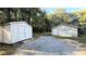 Two outbuildings flank the gravel drive on a wooded lot at 8083 Highway 166, Douglasville, GA 30135