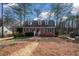 Charming brick home with dormer windows and landscaped front yard surrounded by mature trees on a sunny day at 1835 Tree Top Way, Marietta, GA 30062