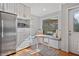 Breakfast nook area with a built-in bench, stainless steel refrigerator, and a view of the backyard at 1835 Tree Top Way, Marietta, GA 30062