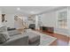Bright living room with hardwood floors, a gray sectional sofa, and a staircase leading to the second floor at 1835 Tree Top Way, Marietta, GA 30062