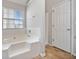 Bright bathroom featuring a tub with tiled walls and a window, creating a serene and inviting atmosphere at 4768 Score Ct, Snellville, GA 30039