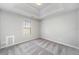 Bedroom featuring neutral carpet and tray ceiling at 4768 Score Ct, Snellville, GA 30039