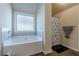 Bathroom featuring a tub, tiled walls, window and separate shower at 879 Tranquil Way, Hampton, GA 30228