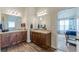 Bathroom with dual sinks and granite counters, wood-look flooring and open doorway at 879 Tranquil Way, Hampton, GA 30228
