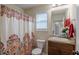 Bathroom with a decorative shower curtain, window, and vanity at 879 Tranquil Way, Hampton, GA 30228