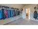 Large walk-in closet with open door and neutral carpeting at 879 Tranquil Way, Hampton, GA 30228