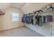 Spacious walk-in closet with ample storage, hanging racks and neutral carpeting at 879 Tranquil Way, Hampton, GA 30228