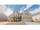 Inviting brick home with a covered porch, two-car garage, and beautifully maintained front yard at 879 Tranquil Way, Hampton, GA 30228
