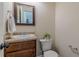 Comfortable half bathroom featuring a wood cabinet, designer faucet, and a framed mirror at 879 Tranquil Way, Hampton, GA 30228