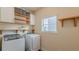 Convenient laundry room with washer, dryer, and ample shelving for storage solutions at 879 Tranquil Way, Hampton, GA 30228