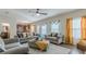 Spacious living room featuring plush sofas, ottoman, and decorative curtains at 879 Tranquil Way, Hampton, GA 30228