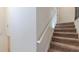 Carpeted staircase with a simple white handrail against a neutral wall at 879 Tranquil Way, Hampton, GA 30228
