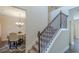 Inviting staircase with carpeted steps and decorative metal railing adjacent to a dining room at 879 Tranquil Way, Hampton, GA 30228