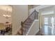 Inviting staircase with carpeted steps and decorative metal railing adjacent to an entryway at 879 Tranquil Way, Hampton, GA 30228