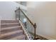 Elegant carpeted staircase with a wooden handrail and wrought iron spindles at 879 Tranquil Way, Hampton, GA 30228