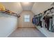 Walk-in closet with carpet, a window and rods for clothing at 879 Tranquil Way, Hampton, GA 30228