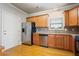 Well-lit kitchen featuring stainless steel appliances, wooden cabinets, and hardwood floors at 140 Ryan Ln, Covington, GA 30014