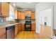 Well-lit kitchen with light wood cabinets and hardwood floors, leading to a living area with fireplace at 140 Ryan Ln, Covington, GA 30014